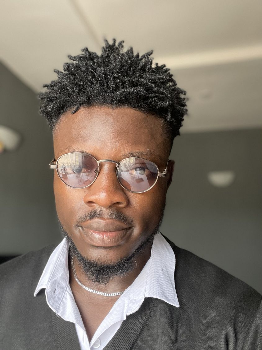 Portrait of Kash in round glasses and a white collar