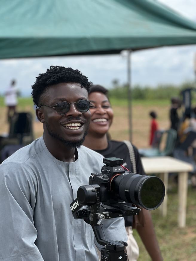 Laughing on set beside a camera on a gimbal