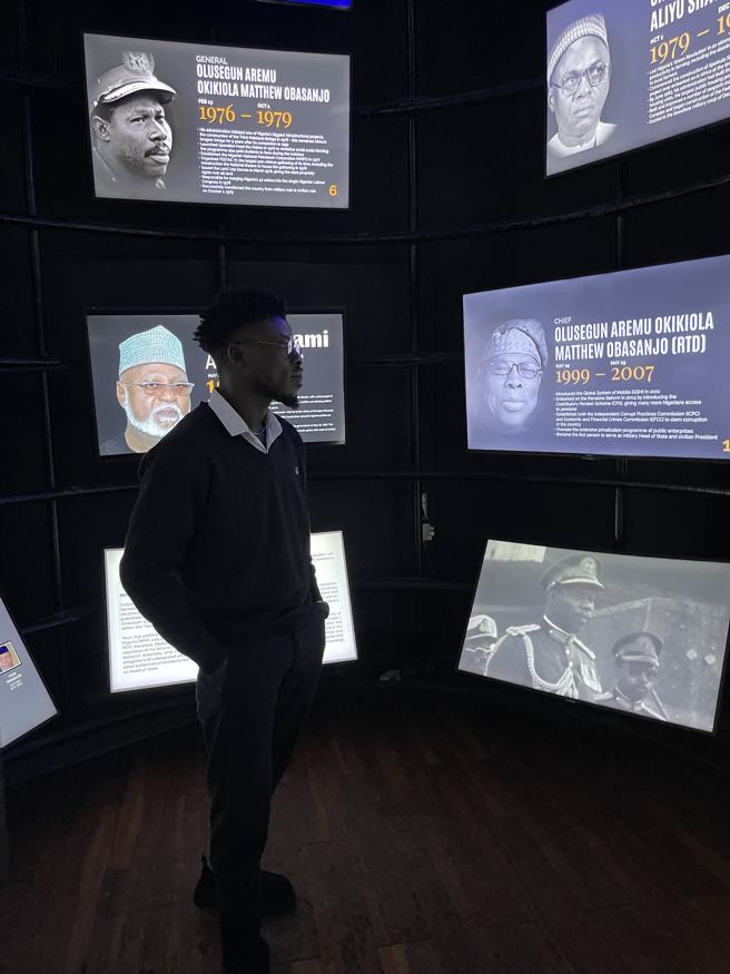 Standing in a dark gallery of lit screens